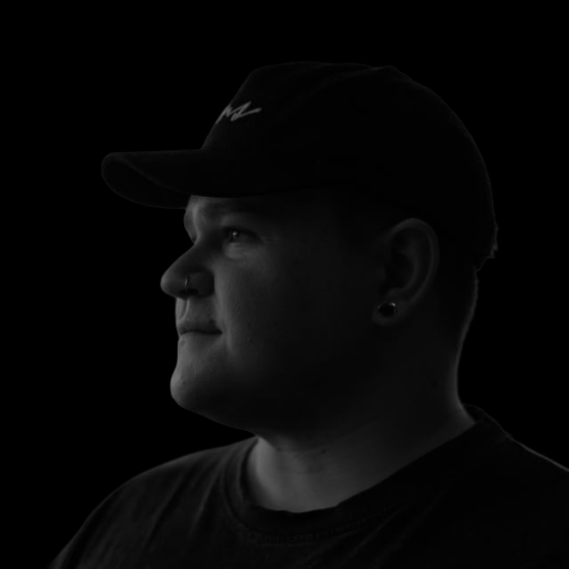 Amar Elkaz in profile, treated with warm amber and violet light